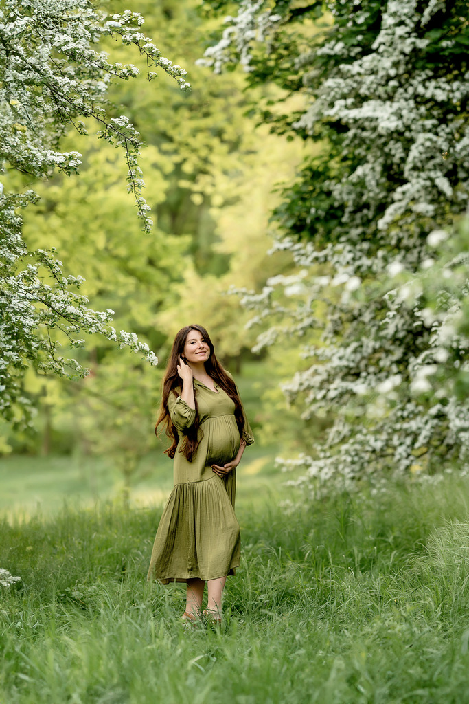 Photoshoot of a pregnant woman in Krakow. Photoshoot in a blooming forest.